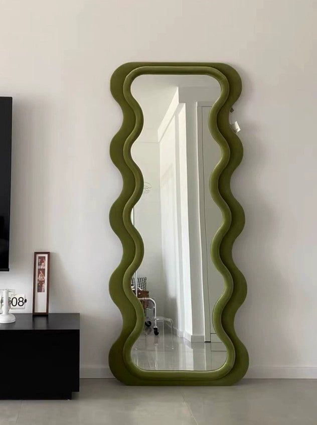 green fabric upholstered standing mirror