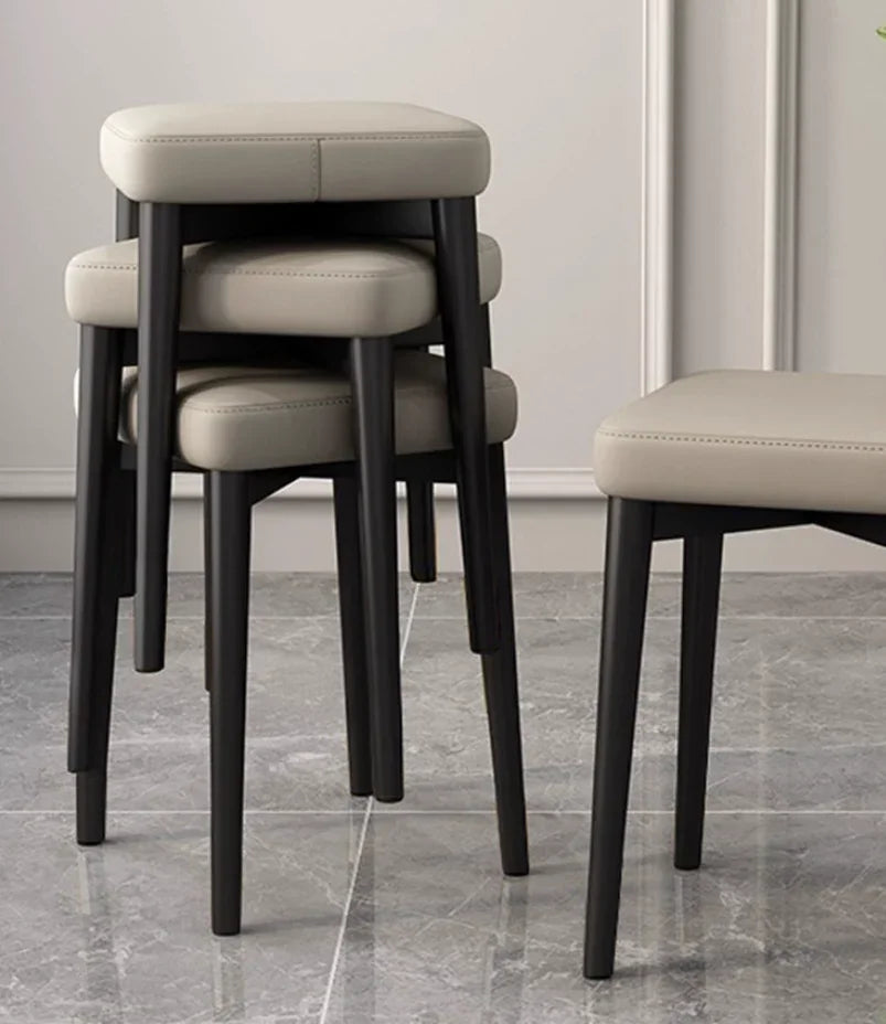 Modern beige upholstered stools with black legs, stackable design for home or office use