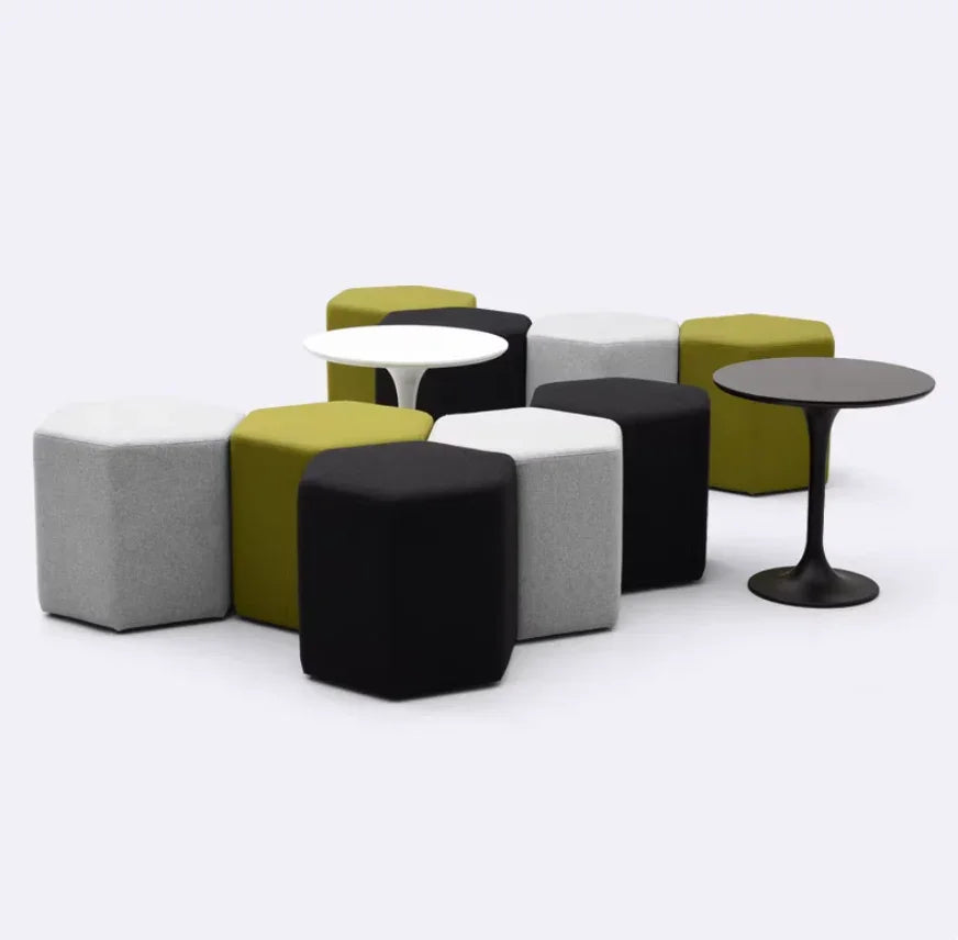 Modern hexagonal ottomans in black, white, gray, and green with sleek round tables for home or office use