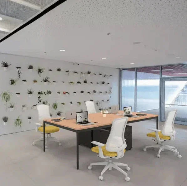 Modern office furniture with white chairs, wooden table, and green wall plants for stylish workspace design