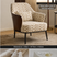 A modern accent chair with deep coffee-colored leather side panels and black metal legs, upholstered in a beige and brown tree-leaf patterned fabric. The image includes text overlays detailing the pattern, dimensions, and fabric features.