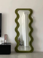 green fabric upholstered standing mirror