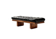 A modern bench with a black tufted leather cushion and a dark brown wooden frame